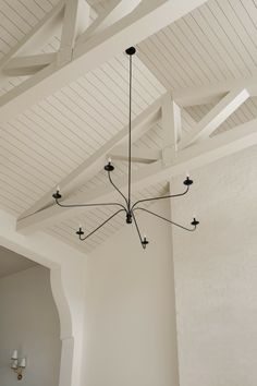 a chandelier hanging from the ceiling in a room with white walls and ceilings