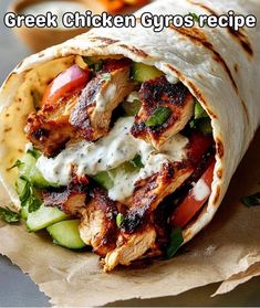 a chicken gyro wrap with lettuce, tomatoes and cucumbers