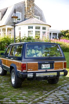 an old station wagon parked in front of a house