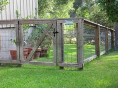 a fenced in area with potted plants on the grass