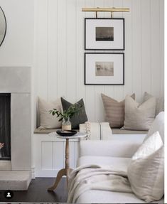 a living room filled with furniture and a fire place in front of a white wall