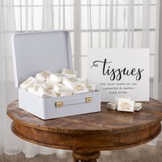 a white box filled with soaps sitting on top of a table next to a sign