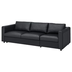 a black leather couch sitting on top of a white floor