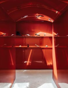 the inside of a red room with shelves and shoes on it's sides,