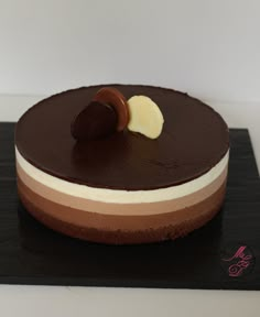 a chocolate cake with white and brown icing on a black plate, ready to be eaten