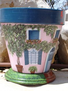 a potted planter with a house painted on it