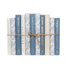 a stack of blue and white books tied with a rope