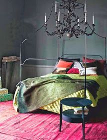 a bedroom with a chandelier hanging from the ceiling and pink rug on the floor