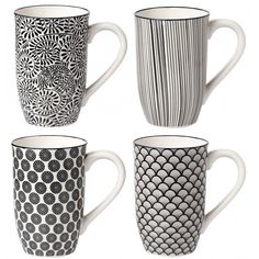 four coffee mugs with black and white designs on them, all lined up in a row