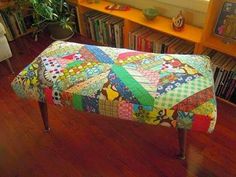 a patchwork bench in front of a bookshelf