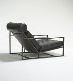 a black leather recliner chair sitting on top of a white floor next to a metal frame