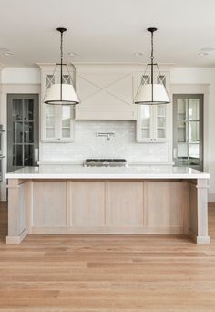 a large kitchen with two pendant lights over the island