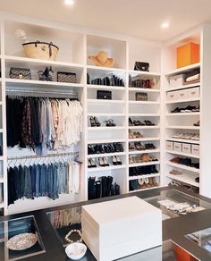 an organized closet with white shelving and drawers