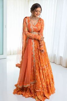 Sherbet orange tiered lehenga with all-over jungle print. Comes with hand embroidered blouse, net dupatta and square cutdana belt. Component: 4 Pattern: Print and Embroidery Type Of Work: Jungle Print, Sequins, Cutdana, Dabka Work and Moti Neckline: V neck Sleeve Type: Full Fabric: Georgette and Net Color: Orange Other Details:  Embroidered dupatta with scallop border Gathered sleeves Low back with tie up and tassels Padded blouse Occasion: Sangeet - Aza Fashions Payal Zinal, Orange Indian Outfit, Lehenga Cape, Paulmi And Harsh, Pleated Lehenga, Purple Lehenga, Orange Lehenga, Cape Set, Lehenga Pattern