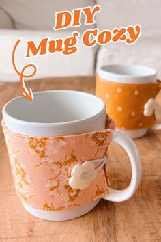 two coffee mugs sitting next to each other on top of a wooden table with the words diy mug cozy