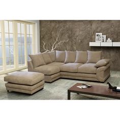 a living room with a large sectional couch and footstool next to a coffee table