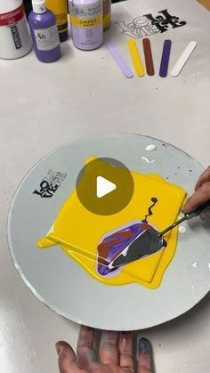 someone is painting a yellow shirt on a plate