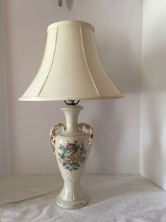 a lamp that is sitting on top of a white table cloth next to a wall