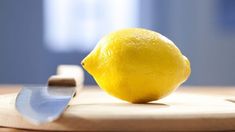 a lemon sitting on top of a cutting board