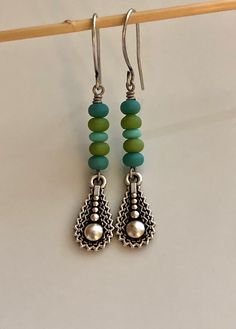 "blue and green glass earrings boho earrings dangle long bohemian earrings Small blue and green matte glass beads were stacked on top of antiqued silver plated teardrop charms. Hook ear wires are antiqued silver plated brass. Length of earrings from top of ear wires is 2 1/4\". Glass beads measure 4mm. Teardrop charm measures 18mm long, not quite 3/4\". You can enter my shop here: gypsydangles.etsy.com" Bohemian Green Teardrop Earrings With Ear Wire, Green Bohemian Long Drop Earrings, Green Bohemian Beaded Earrings In Sterling Silver, Handmade Blue-green Bohemian Jewelry, Green Bohemian Dangle Beads, Bohemian Green Beaded Sterling Silver Earrings, Green Bohemian Earrings With Dangling Charms, Blue Czech Glass Earrings With Dangling Beads, Blue Glass Bohemian Earrings