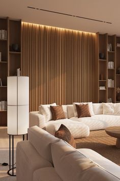 a living room filled with white furniture and lots of bookshelves on the wall