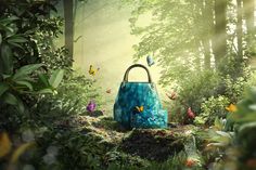 a blue purse sitting on top of a forest filled with lots of green plants and butterflies