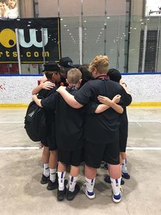 a group of young people standing next to each other on top of a hockey court