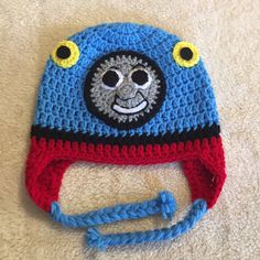 a crocheted hat with a smiling face on it