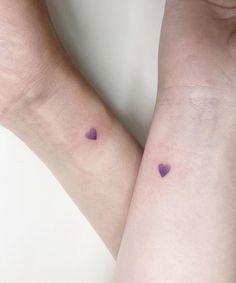 two small hearts tattoo on both wrist and arm, with one heart in the middle