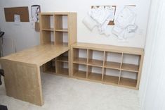 a desk and shelves in a room with carpeted flooring on the floor, next to a white wall