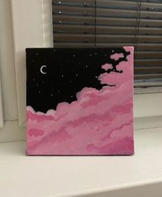 a pink and black painting sitting on top of a window sill