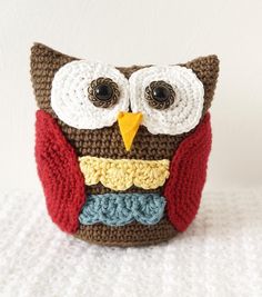 a crocheted owl sitting on top of a white surface