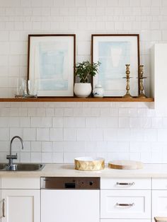 two framed pictures above a kitchen sink