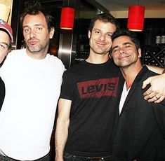 four men are posing for the camera at a party