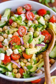 a salad with chickpeas, tomatoes, cucumber and lettuce