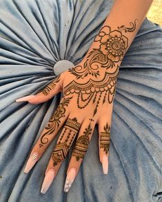 a woman's hand with henna tattoos on it