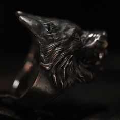 Blank eyes, bare silver teeth and a hyper aggressive expression.  You can almost hear the deep growl and see the drool running from the mouth of this very realistic Sterling Silver Wolf Beast Ring. This ring is finished in a beautiful combination of blackened oxidation with a contrasting highpolished surface of the eyes and teeth. The inside has the Book of Alchemy crest sculpted in embraced by Gothic ornamental details. The weight is 59 grams (based on a size 64) and measures 36.3mm from top to Blank Eyes, Wolf Beast, Silver Teeth, Mens Skull Rings, Fire Jewelry, Silver Wolf, Star Ring, Skull Ring, Wooden Case