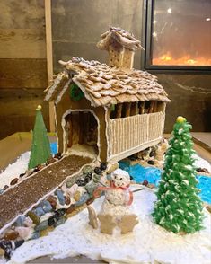 a gingerbread house with snowmen and trees