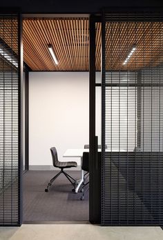 an office with glass partitions and a white table in front of the door that leads to another room