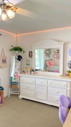 a bedroom with white furniture and lights on the ceiling