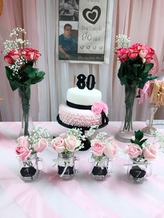 a table topped with vases filled with pink roses and white baby's breath