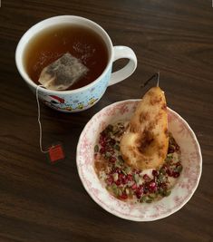 a cup of tea next to a plate with food on it