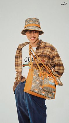 a young man is holding a gucci bag