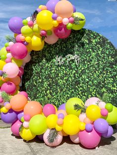 a bunch of balloons that are in front of a sign with the words it's party written on it