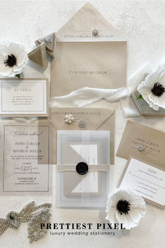 the wedding stationery is laid out with white flowers