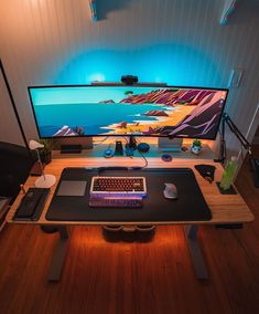 a computer desk with a keyboard, mouse and monitor on it in front of a wall