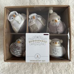 four knitted owl ornaments in a box on a white blanket with the words wondershop written above them