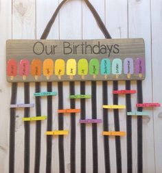 a wooden sign that says, our birthdays are made out of colored paper clips