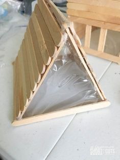 a triangle shaped wooden object sitting on top of a white tile counter next to other wood pieces