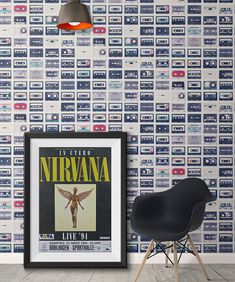 a chair in front of a wall with a poster on it and a lamp hanging from the ceiling